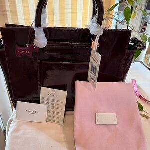 Here’s a Radley large, patent, burgundy tote with an accompanying strap.